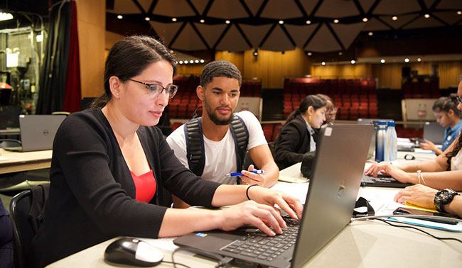 staff member at laptop assisting student with registration