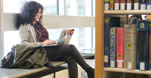 student using laptop in library