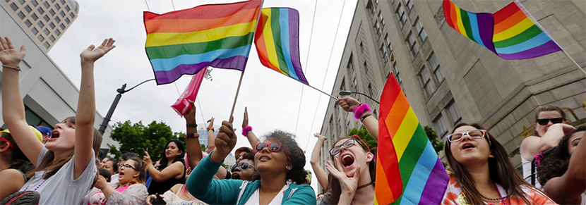 students at a pride event holding rainbow flags