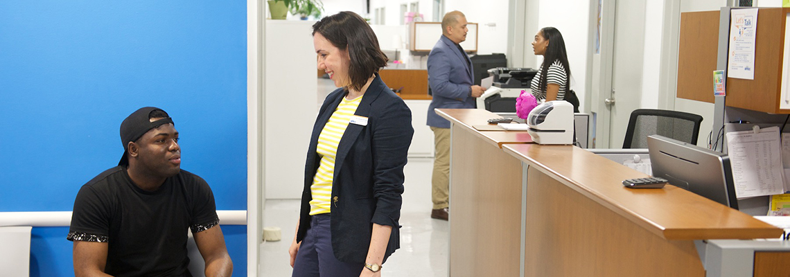 student sitting in waiting area speaking to counselor