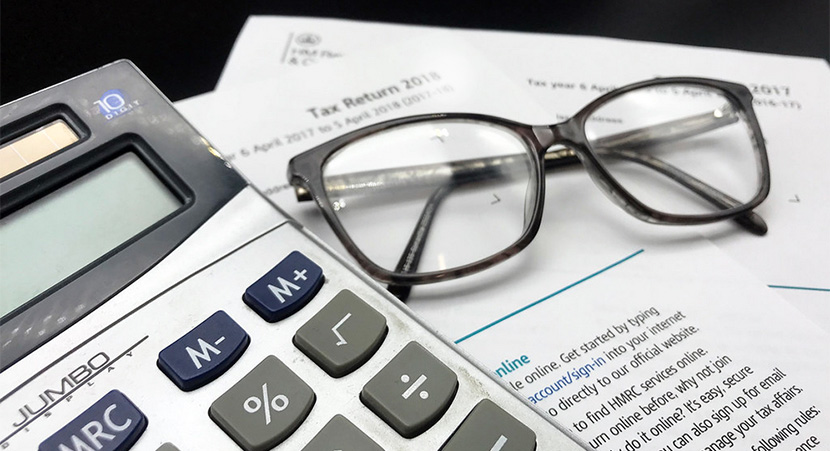 tax forms, calculator and eye glasses