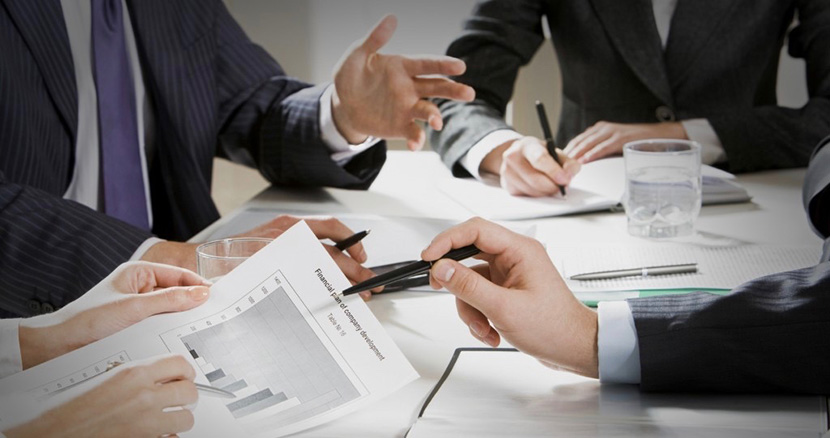 business meeting with several men in suits and papers on table