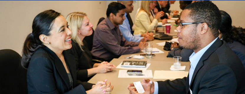 people in business dress speaking to others at a table