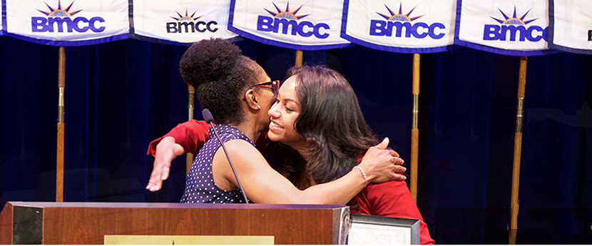 teacher hugging student at podium during Honors Convocation