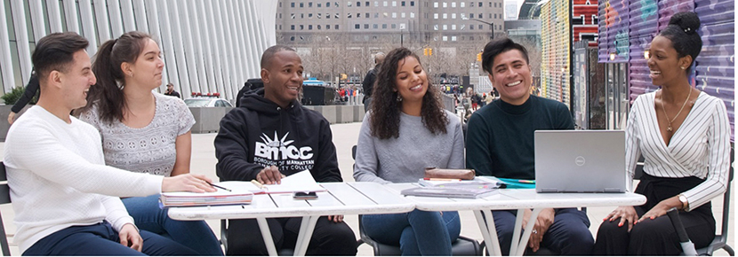 students sitting at tables on BMCC campus