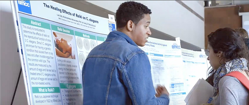 two students looking at a science poster at a symosium