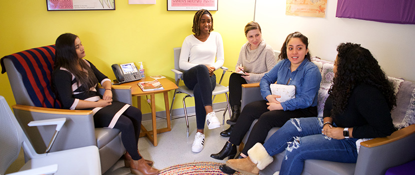 several women chatting in women's resource center lounge room