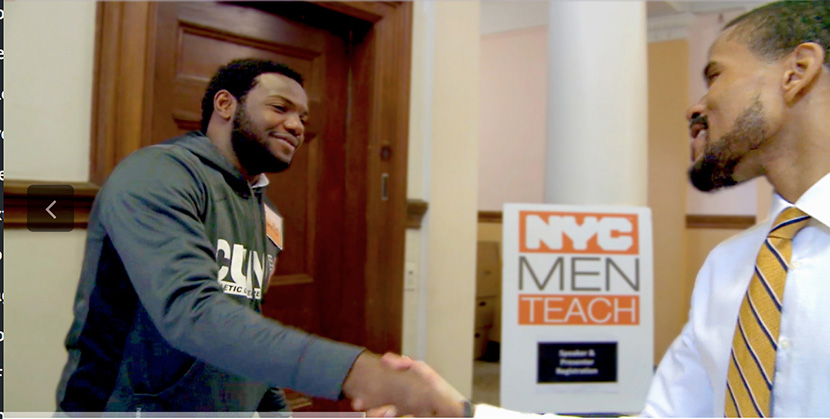 two African American men shaking hands in front of a NYC Men Teach poster