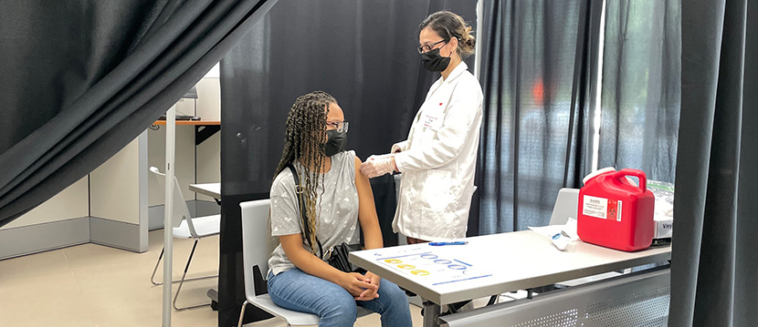 student getting vaccination at the CUNY in the Heights clinic