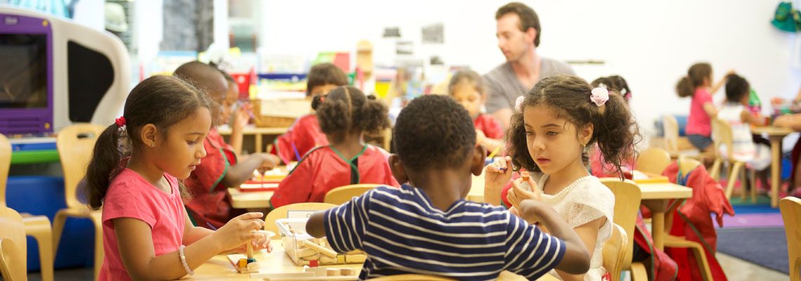 children at a table working on a project