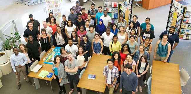 scholarship winners standing around a table in the library